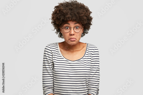 Fotografie, Obraz Studio shot of puzzled beautiful African American female has hesitant and frustr