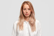 © wayhome.studio  - Headshot of self assured Caucasian female with healthy pure skin, wears loose white shirt, looks directly into camera, has serious expression, contemplates about future plans. Beauty and lifestyle