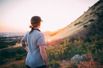 girl hiking and looking at sunset