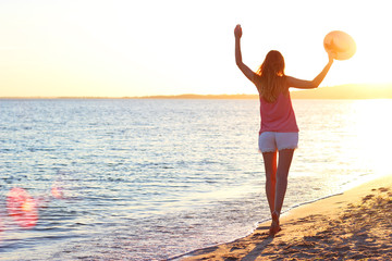 Wall Mural - girl by the sea enjoying the sunset