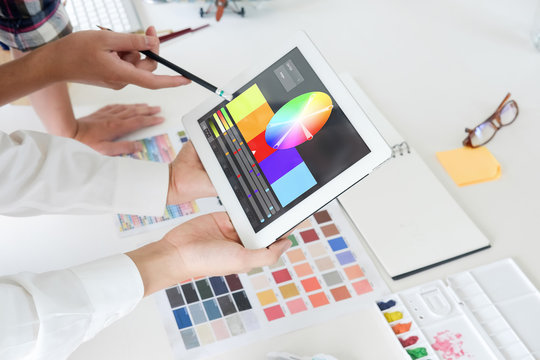 graphic designer working with tablet planing colour in project.
