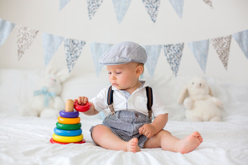 Poster - Cute toddler child, baby boy, playing with colorful toy in sunny bedroom