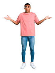 Wall Mural - Standing young african american man having doubts and with confuse face expression while raising hands and shoulders on isolated white background