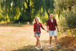 © Mironifamily - Outdoor shot of young couple walking through meadow hand in hand.