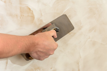 polishing the Venetian plaster on the wall master