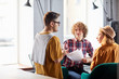 © pressmaster - Three co-workers in casualwear sitting cafe and discussing papers and ideas