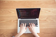 © oatawa - Closeup Woman hands working with coding html and programming on screen laptop with wooden table background, development web, top view.