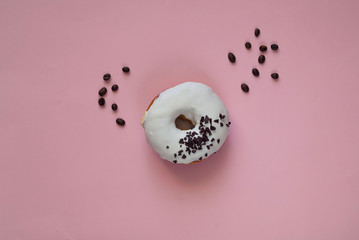 Wall Mural - white glazed donut  with black chocolate sweets on pink background.Flat lay. Food concept,colorful breakfast. Macro concept.