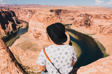 Wall Mural - young man with Magnificent view of Horseshoe bend, Grand Canyon, Arizona, USA.