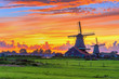 Traditional village at sunset, with dutch windmills, bridge and river on Zaanse Schans, Holland, Netherlands.