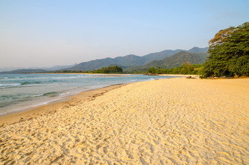 Wall Mural - Beautiful Bureh Beach in the afternoon with yellow sand, green trees, sea and mountains, Sierra Leone, Africa