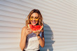 Pretty girl eating a watermelon, wearing yellow sunglasses, enjoying the summer days, outdoors.