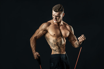 Wall Mural - Handsome muscular strong man doing pulling exercise and working hard.