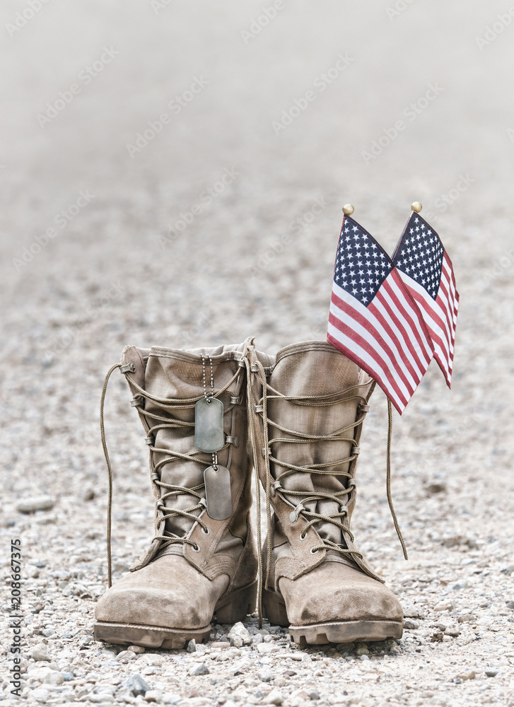 Old military combat boots with dog tags and two small American flags ...