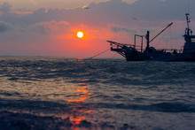 Fishing Boat At Sea In The Sunset