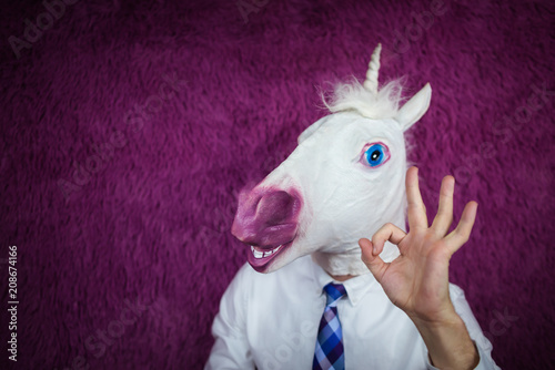 Fotografía Freaky young man in comical mask stands on the purple background