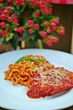 Homemade Italian Chicken Parmesan with Spaghetti pasta on a white plate with flower background. Selective focus.