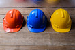 © sirastock - Yellow, Orange and Blue protective safety helmet