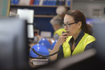 Sticker - Woman in industrial control room using radio to give instructions