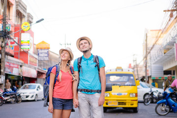 Wall Mural - Travel and tourism. Couple of backpackers walking together on asian street.