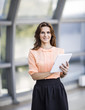 © yurolaitsalbert - successful business woman with digital tablet standing in the lobby of a modern office