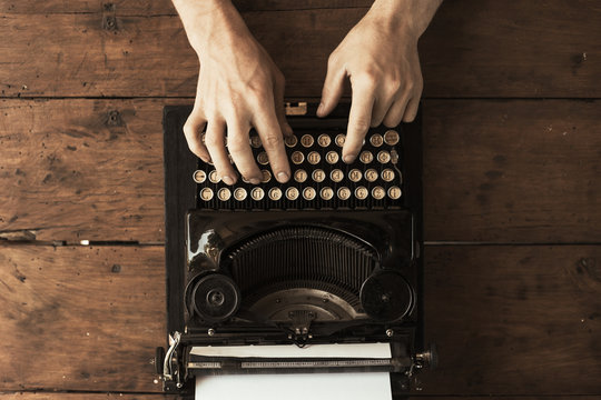 Young man's hands typing on an antique vintage typewriter