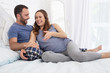 © Viacheslav Yakobchuk - Funny jokes. Joyful man and pregnant woman lying on bed and laughing
