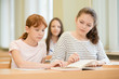 © Evgeny Sumin - 3 student girls are sitting at a Desk