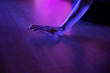 Open hand resting on floor in violet light