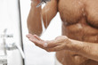 © Drobot Dean - Close up of a naked man putting shower gel