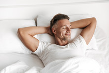 Satisfied man relaxing in bed