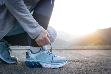  Sport runner woman tying laces before training. Marathon.