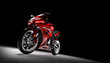 Front view of red sports motorcycle in a spotlight