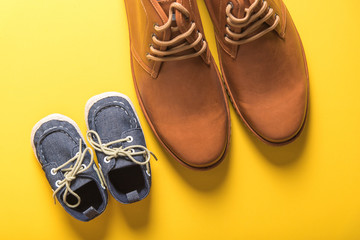 father and son shoes on yellow background , father day concept