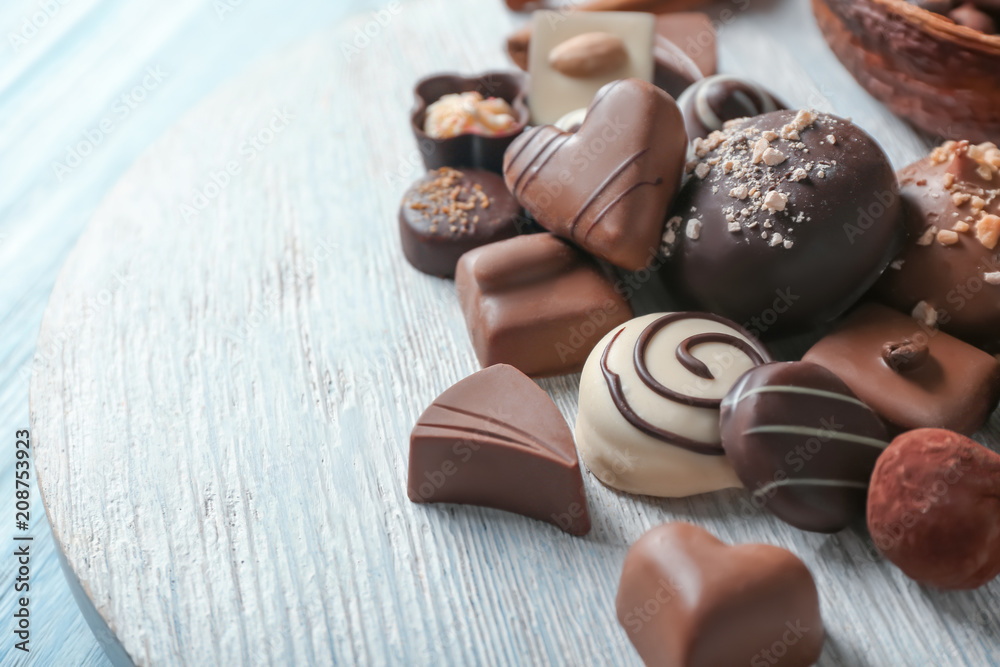 Tasty chocolate candies on wooden stand