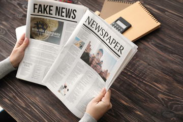 Woman reading morning newspaper at table