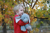 Fototapeta Młodzieżowe - Petit garçon dans le jardin avec son doudou éléphant en peluche. Gros câlin et tendresse