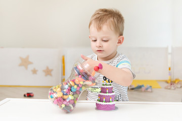 A little boy is playing with beads and other small toys. Pastime in the children garden or play center