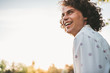 © iuricazac - Outdoor side view shot of handsome happy young freckled male smiling and curly hair posing in the city park looking a side. Copy space for your advertising. People, lifestyle and emotion