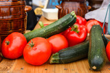 Fototapeta Kuchnia - Fresh vegetables - tomatoes and zucchini on a picnic table on a summer day.
