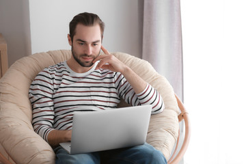 Male freelancer working with laptop in home office