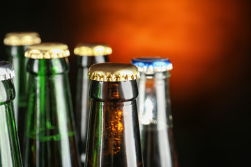 Fresh beer in glass bottles on dark background