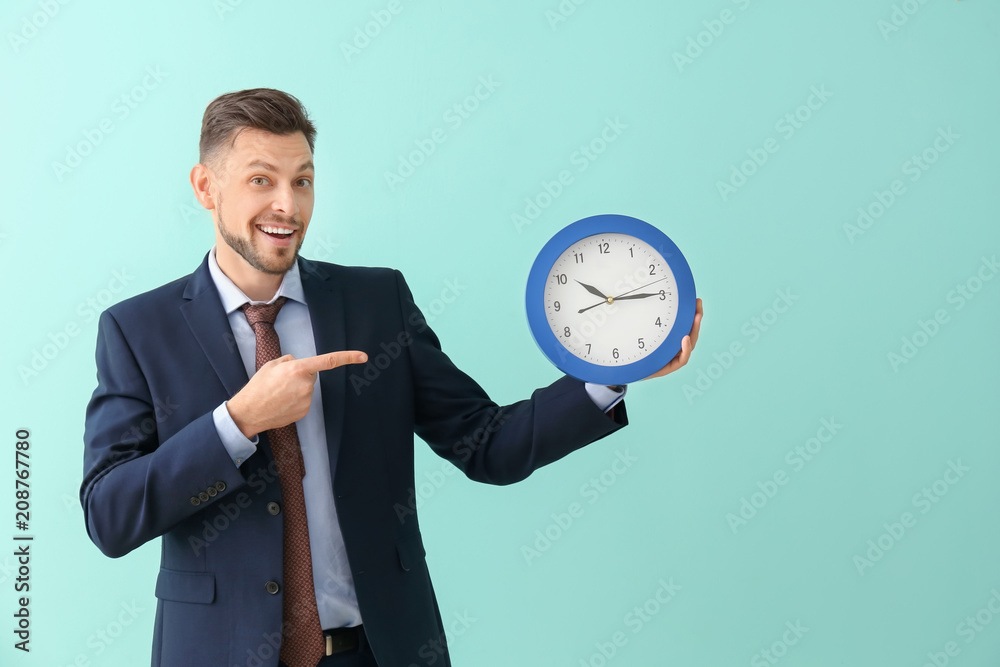 Businessman with clock on color background. Time management concept