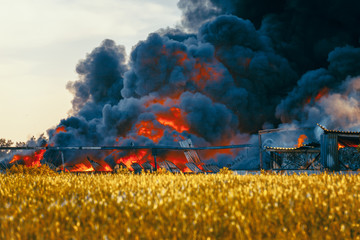 Landfill fire among fields and huge black smoke cloud