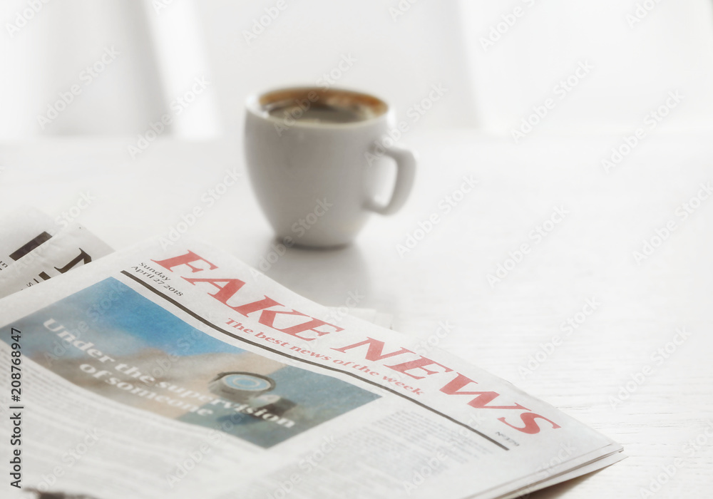 Morning newspapers and cup of hot coffee on white table
