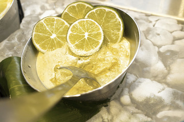 Cut lime circles in a stainless steel bowl with yellow lime accented facial mask for woman's beauty