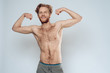 © freeograph - Bare redhead man shows muscles.