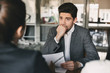 © Drobot Dean - Business, career and placement concept - european man 30s biting his fist and worrying during job interview in office, with group of specialists