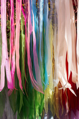 background of strips of silk fabric of various colors
