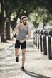 © Vadym - Young fit muscular man running in the city park